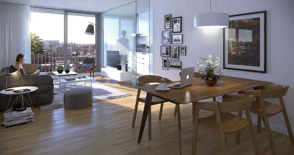 Living con mesa, sillas y ventanal luminoso de un apartamento en edificio Dómini Roxlo del estudio de arquitectos Pablo Szames